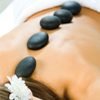 A person receiving a hot stone massage, with smooth, heated stones placed along their spine